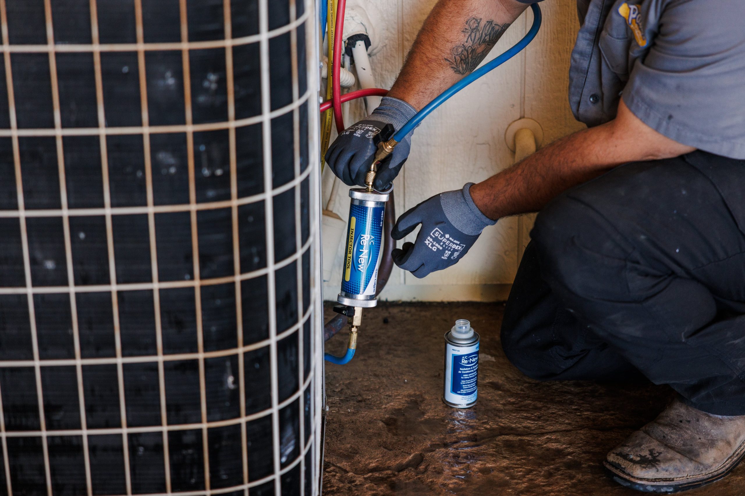 Technician servicing an outdoor air-conditioning condenser unit